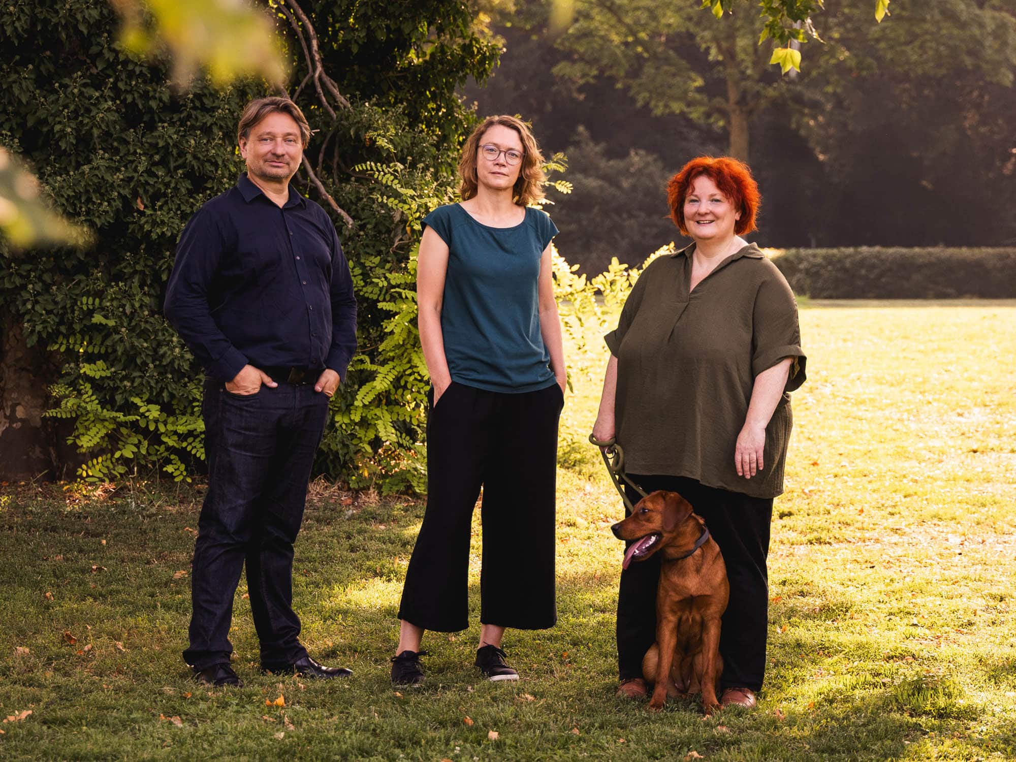 Das Team der Mission Regenerativ steht gemeinsam im Park bei Sonnenschein